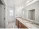 Bathroom featuring double sinks, granite countertops, and a large mirror with modern lighting at 15076 W 93Rd Ave, Arvada, CO 80007