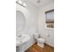 Bright bathroom with a white sink and toilet and a window with natural shades at 15076 W 93Rd Ave, Arvada, CO 80007