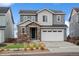 Charming two-story home featuring gray siding, a stone-accented entrance, and a well-maintained front yard at 15076 W 93Rd Ave, Arvada, CO 80007