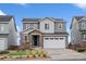 Charming two-story home featuring gray siding, a stone-accented entrance, and a well-maintained front yard at 15076 W 93Rd Ave, Arvada, CO 80007