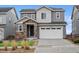 Charming two-story home featuring gray siding, a stone-accented entrance, and a well-maintained front yard at 15076 W 93Rd Ave, Arvada, CO 80007
