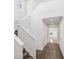 Bright, two-story hallway features a staircase, neutral decor, and wood-look flooring at 15076 W 93Rd Ave, Arvada, CO 80007