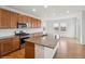Modern kitchen featuring wood cabinets, granite countertops, stainless steel appliances, and a spacious island at 15076 W 93Rd Ave, Arvada, CO 80007