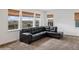 Bright living room with a comfortable black sectional sofa and large windows offering scenic views at 15076 W 93Rd Ave, Arvada, CO 80007