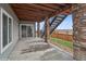 Covered patio with stone pillars, wooden ceiling, and sliding glass doors with partial fence view at 15076 W 93Rd Ave, Arvada, CO 80007