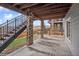 Outdoor patio area featuring stone pillars, wooden ceiling, and wrought iron staircase with partial fence view at 15076 W 93Rd Ave, Arvada, CO 80007