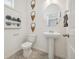 Clean and modern half-bathroom with pedestal sink, decorative mirror, and elegant wall decor at 1356 S Boston Ct # B, Denver, CO 80247