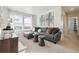 Bright living room features comfortable gray sectional sofa, stylish tables, and picturesque windows at 1356 S Boston Ct # B, Denver, CO 80247