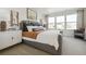 Elegant main bedroom features a luxurious gray bed, plush pillows, and bright windows with neighborhood views at 1356 S Boston Ct # B, Denver, CO 80247