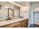 Bathroom with double sink vanity, sleek black hardware, and a glass enclosed shower at 2491 W 69Th Pl, Denver, CO 80221