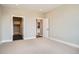 Carpeted bedroom featuring neutral paint and trim, with doorways leading to a closet and the kitchen at 2491 W 69Th Pl, Denver, CO 80221