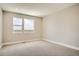 Bright bedroom featuring neutral carpet, white trim, and two large windows with neighborhood views at 2491 W 69Th Pl, Denver, CO 80221