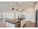 Well-lit kitchen featuring a spacious island, modern appliances, and pendant lighting at 2491 W 69Th Pl, Denver, CO 80221