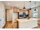 Stylish kitchen with stainless appliances, an island, wood cabinets, and pendant lights at 2491 W 69Th Pl, Denver, CO 80221