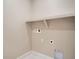 Laundry room with white tile floor and a shelf. The room has an electrical outlet and hookups at 2491 W 69Th Pl, Denver, CO 80221