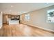 Open living space with hardwood floors and a view into the kitchen with stainless appliances at 2491 W 69Th Pl, Denver, CO 80221