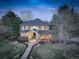 Inviting two-story home featuring a covered front porch, well-manicured lawn, and mature trees at 6724 S Yates Ct, Littleton, CO 80128