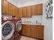 Well-equipped laundry room with modern washer and dryer, ample cabinetry, and a convenient sink at 6724 S Yates Ct, Littleton, CO 80128