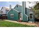 Charming green home with well-maintained backyard, wooden steps, and beautiful stone walkway at 7680 Elmwood St, Littleton, CO 80125