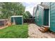 Green home featuring lush backyard with shed, grass lawn, and stone paver patio at 7680 Elmwood St, Littleton, CO 80125