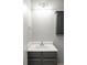 A clean half bath features gray cabinets and a white sink, providing a fresh and simple design at 7680 Elmwood St, Littleton, CO 80125
