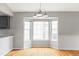 Bright dining area featuring large windows, hardwood floors and a modern chandelier at 7680 Elmwood St, Littleton, CO 80125