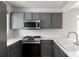Updated kitchen featuring stainless steel appliances and sleek gray cabinets at 7680 Elmwood St, Littleton, CO 80125