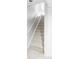 A carpeted staircase is well-lit and lined with white railings, ensuring a safe transition at 7680 Elmwood St, Littleton, CO 80125