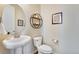 Stylish half bathroom with a pedestal sink, decorative mirror, and modern fixtures at 25669 E Fair Dr, Aurora, CO 80016