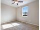 A bright, carpeted bedroom with a ceiling fan and natural light from a single window at 25669 E Fair Dr, Aurora, CO 80016