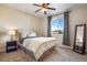 A cozy bedroom featuring a comfortable bed, a nightstand, and a full length mirror at 25669 E Fair Dr, Aurora, CO 80016