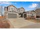 Charming two-story home with a three-car garage, stone accents, and well-maintained landscaping at 25669 E Fair Dr, Aurora, CO 80016