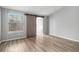 A bedroom is brightly lit and features a sliding barn door closet, wood floors, and a view of a window at 4621 S Fraser Cir # B, Aurora, CO 80015