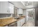 Well-lit kitchen featuring stainless steel appliances, white cabinets, and ample counter space at 4621 S Fraser Cir # B, Aurora, CO 80015