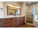 A spa-like bath features wood cabinets, marble counters, and a seamless glass shower at 1552 Colt Cir, Castle Rock, CO 80109