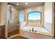 A bright bathroom includes a large tub and a glass shower, both with outside views at 1552 Colt Cir, Castle Rock, CO 80109