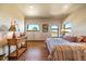 A bedroom featuring hardwood floors, two arched windows, and vintage furniture pieces at 1552 Colt Cir, Castle Rock, CO 80109