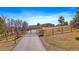 Scenic view of a stunning estate with a gated entrance and a long driveway leading to the beautiful home at 1552 Colt Cir, Castle Rock, CO 80109