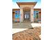 Grand front entrance features stone columns, an arched doorway, a stone path and double wood doors at 1552 Colt Cir, Castle Rock, CO 80109