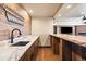 This wet bar features a sink, dark wood cabinets, and light marble countertops at 1552 Colt Cir, Castle Rock, CO 80109