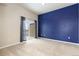 Bright bedroom featuring a blue accent wall and sliding glass door for balcony access at 15475 Andrews Dr # 412, Denver, CO 80239