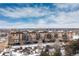 Multi-story apartment building with balconies and snow-covered parking lot at 15475 Andrews Dr # 412, Denver, CO 80239