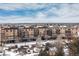 Apartment building with multiple balconies and parking, viewed from above at 15475 Andrews Dr # 412, Denver, CO 80239