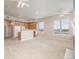 Open-concept living room with a kitchen, ceiling fans, and natural light from large windows at 15475 Andrews Dr # 412, Denver, CO 80239