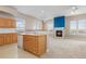 Open-concept living area with a fireplace, carpeted floors, and a breakfast bar at 15475 Andrews Dr # 412, Denver, CO 80239