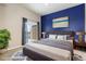 Bedroom featuring a blue accent wall, queen bed, and patio access with natural light at 15475 Andrews Dr # 412, Denver, CO 80239