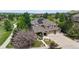 Aerial view showcasing a solar-paneled home with lush landscaping, a circular driveway, and a three-car garage at 5448 El Diente St, Golden, CO 80403