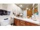 Bathroom featuring wood cabinets, a light countertop, and large mirror at 5448 El Diente St, Golden, CO 80403