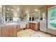 Bright primary bathroom featuring dual vanities, tile floors, and large mirrors with recessed lighting at 5448 El Diente St, Golden, CO 80403