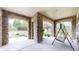 A stone-covered patio features stone pillars, a porch swing, and views of the front yard at 5448 El Diente St, Golden, CO 80403